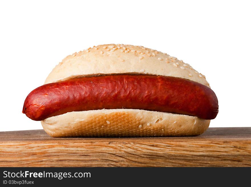 Baked roll with sausageon on wooden table