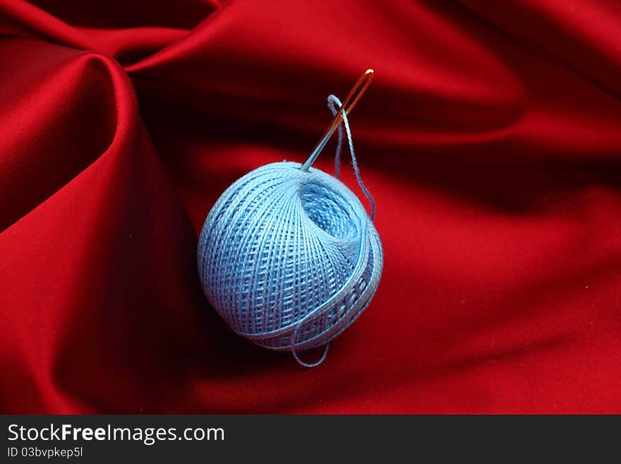 Thread on red silk isolated close up