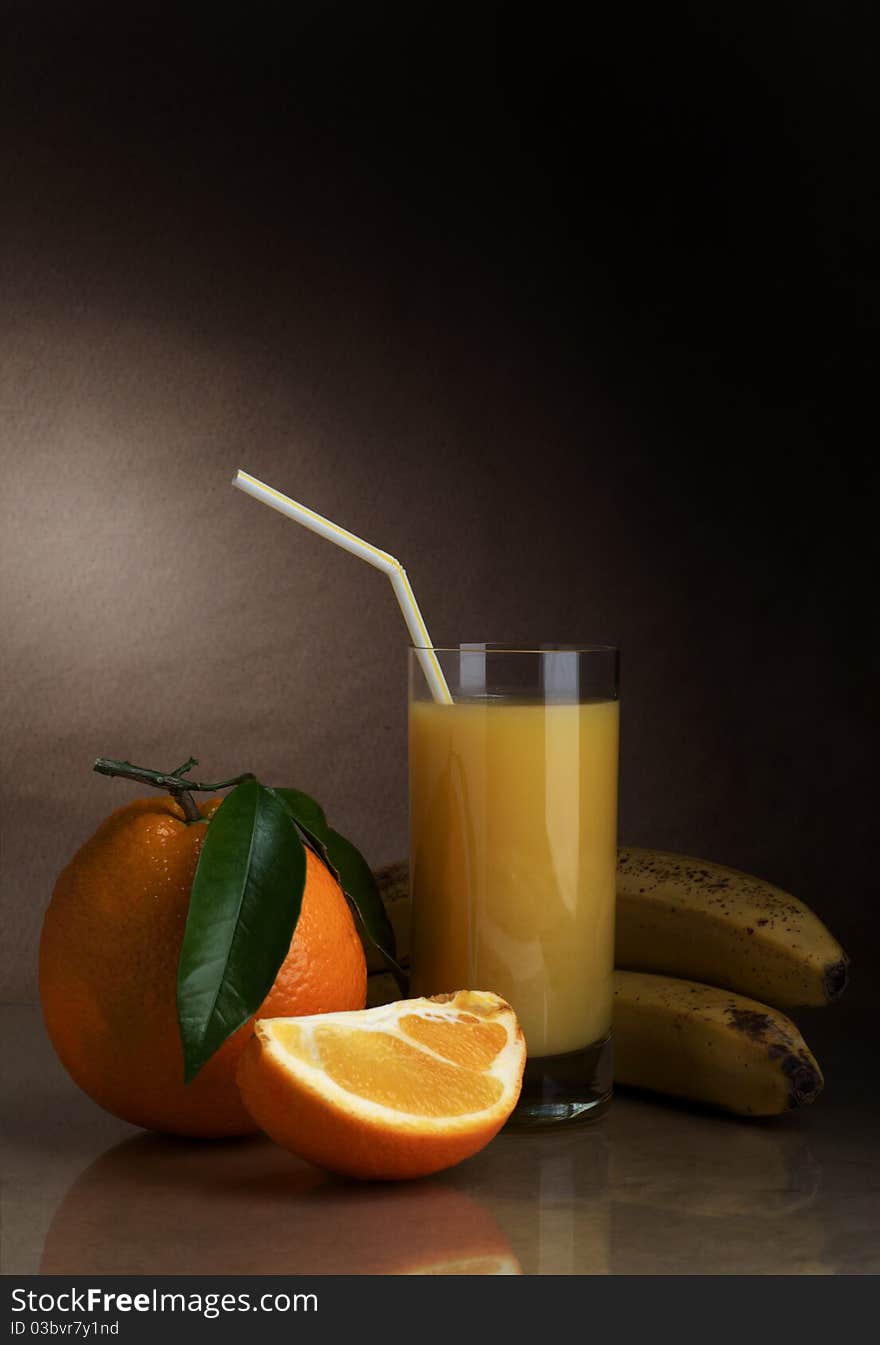 Orange and orange juice in a glass on a dark background