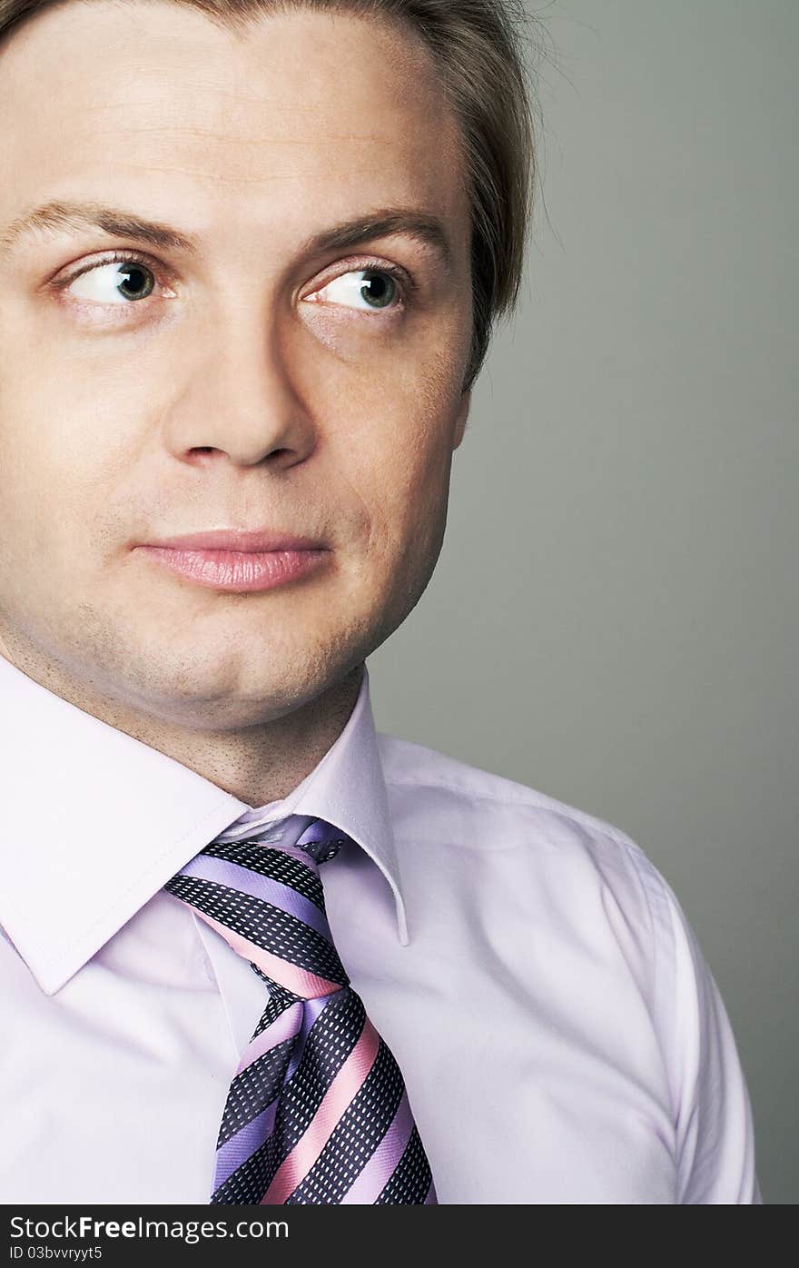 Suspicious young man in studio on the gray background. Suspicious young man in studio on the gray background