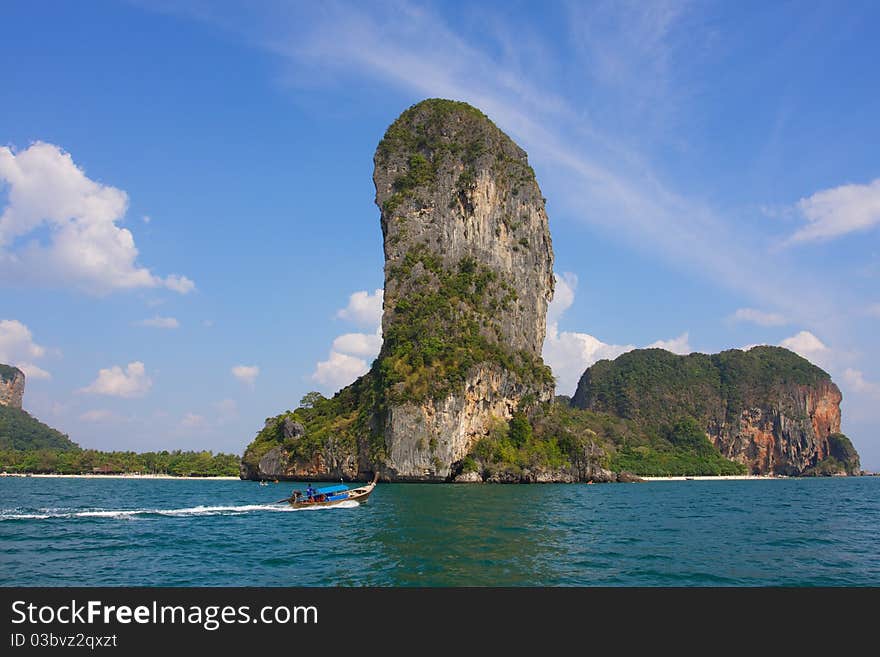 Boat sails past the rocks jutting into the ocean. Boat sails past the rocks jutting into the ocean