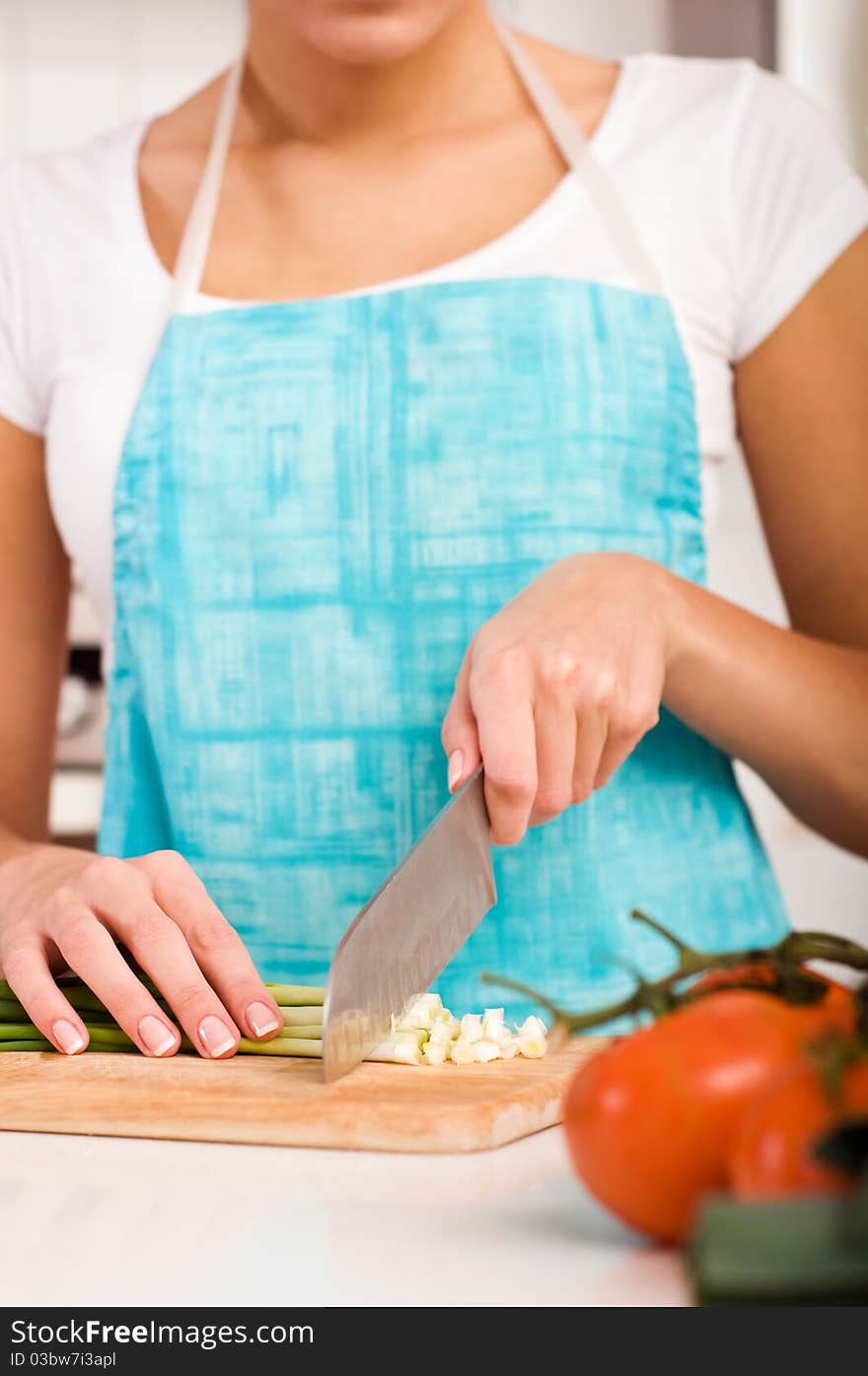 Young Woman cutting vegetables in modern kitchen