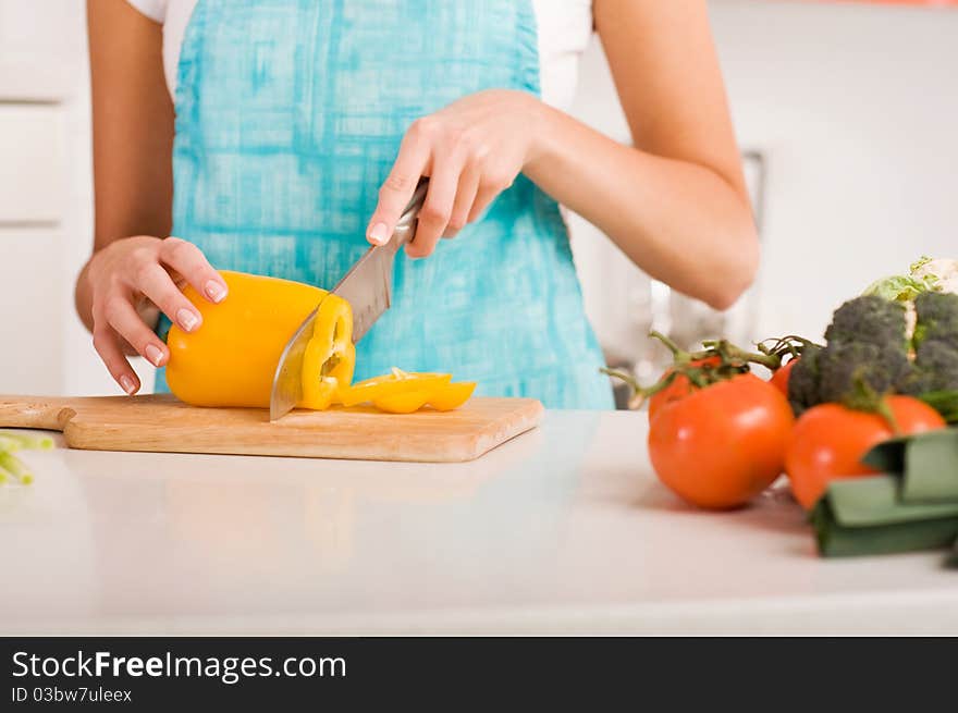 Young woman cutting vegetables in a kitchen