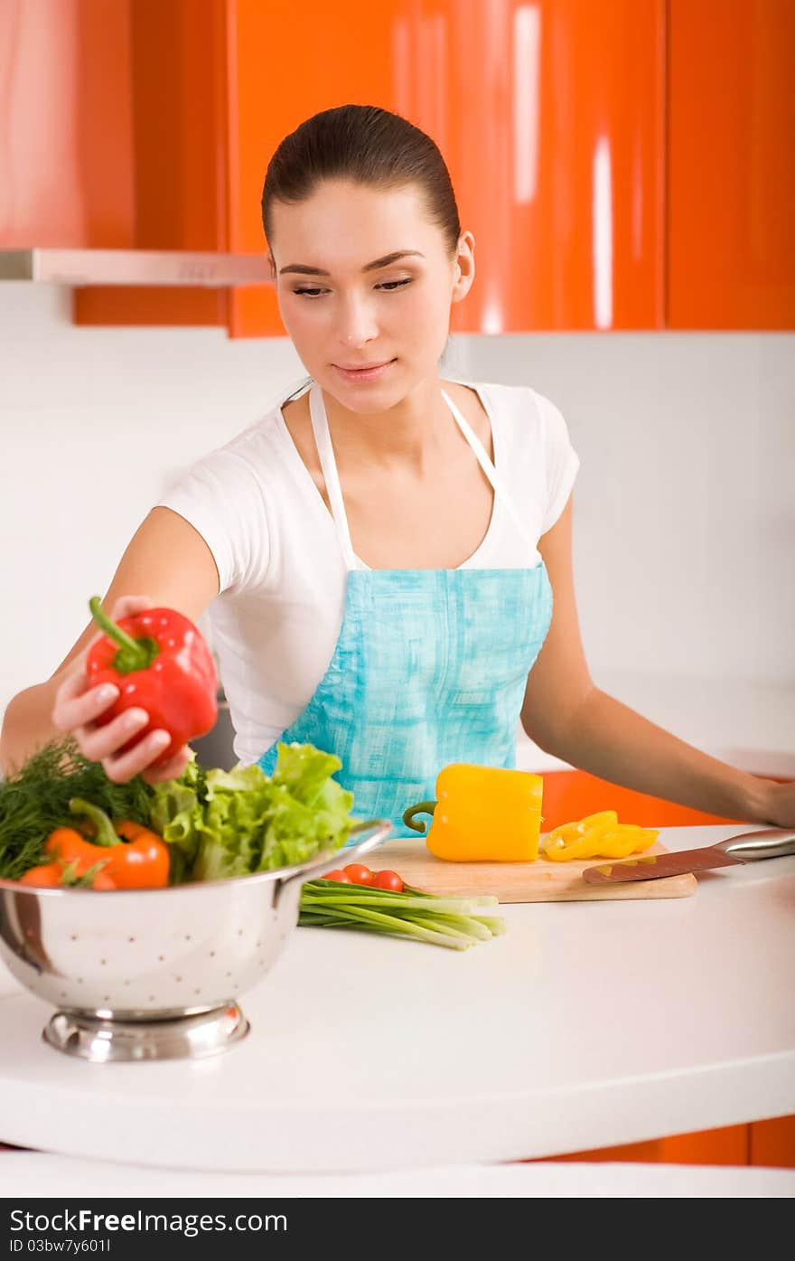 Woman cutting vegetables in modern kitchen