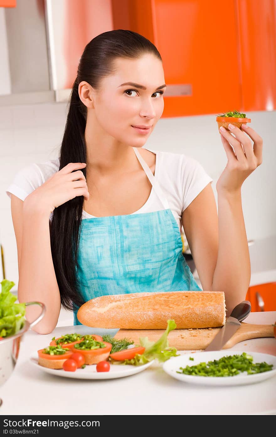 Attractive smiling woman preparing fresh healthy sandwiches in her kitchen