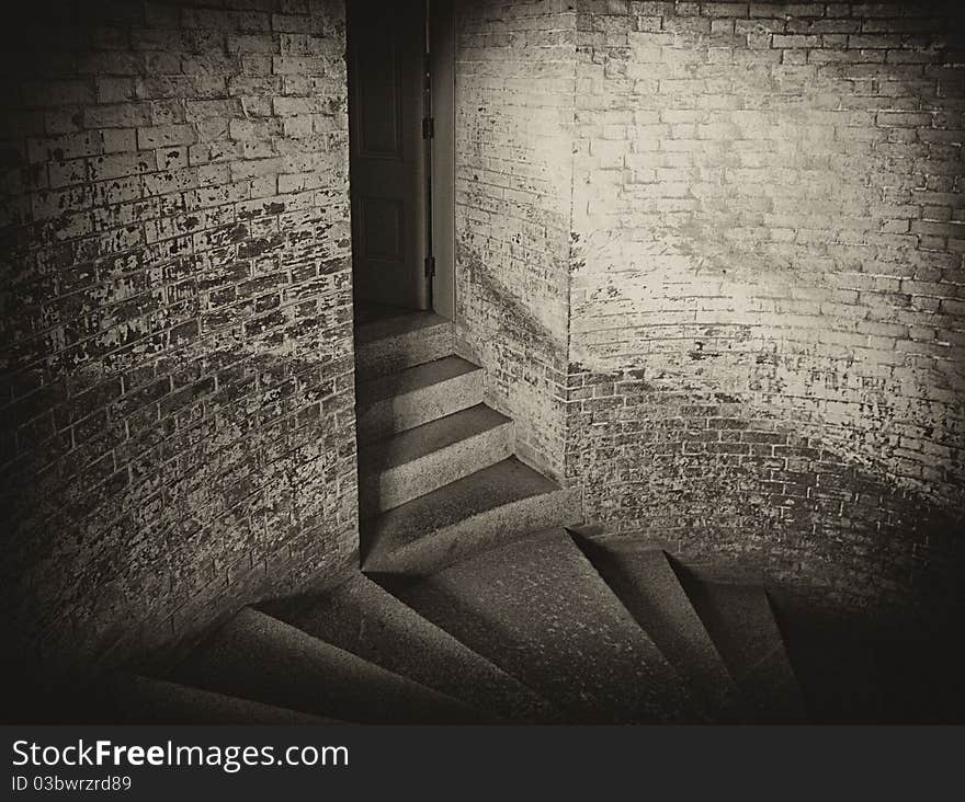 Atmospheric monochrome rendering of cold stone steps and dark doorway in old brick building. Atmospheric monochrome rendering of cold stone steps and dark doorway in old brick building.