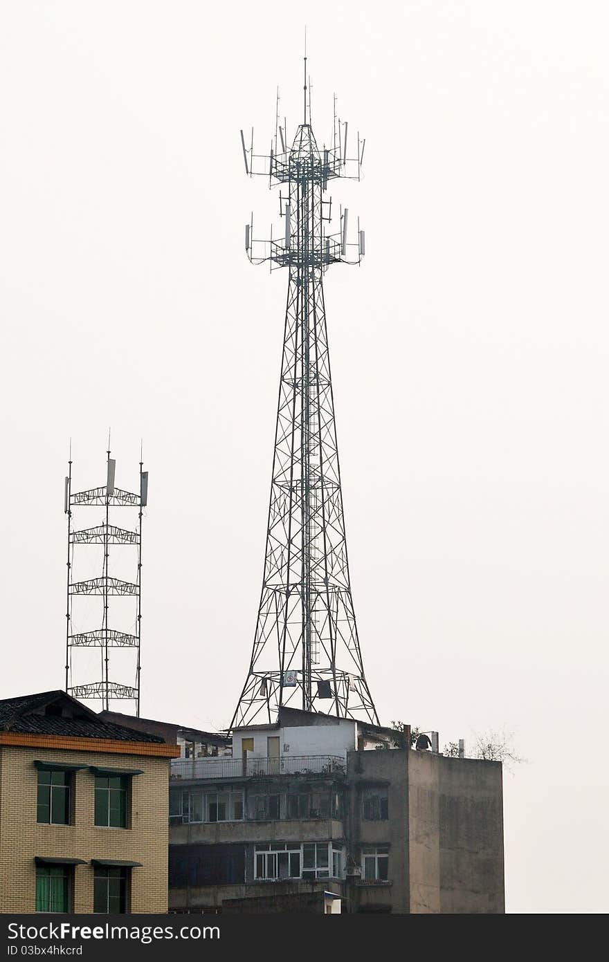 Base station antenna tower on the buildings in a small town. Base station antenna tower on the buildings in a small town.