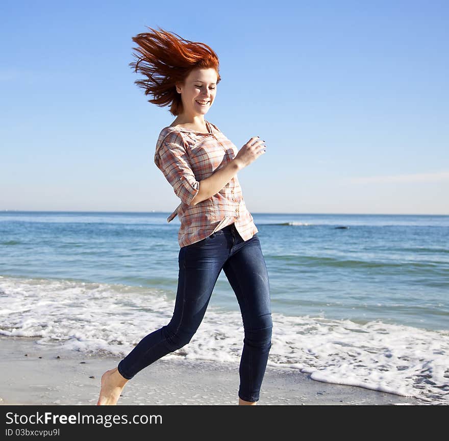 Beautiful young woman running on the beach