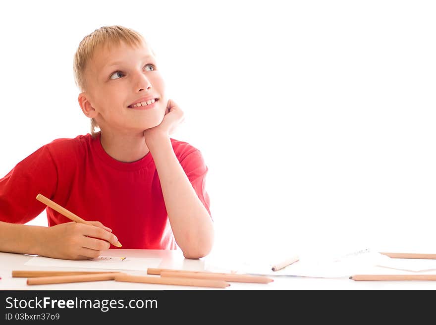 Boy in a red shirt sitting draws