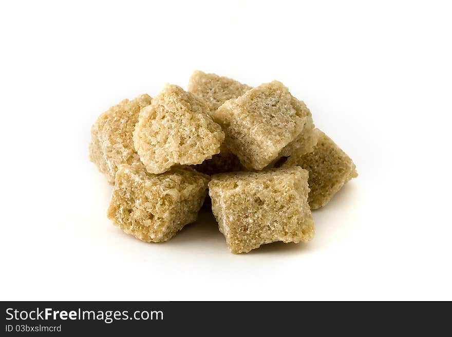 Pile of brown sugar cubes over white