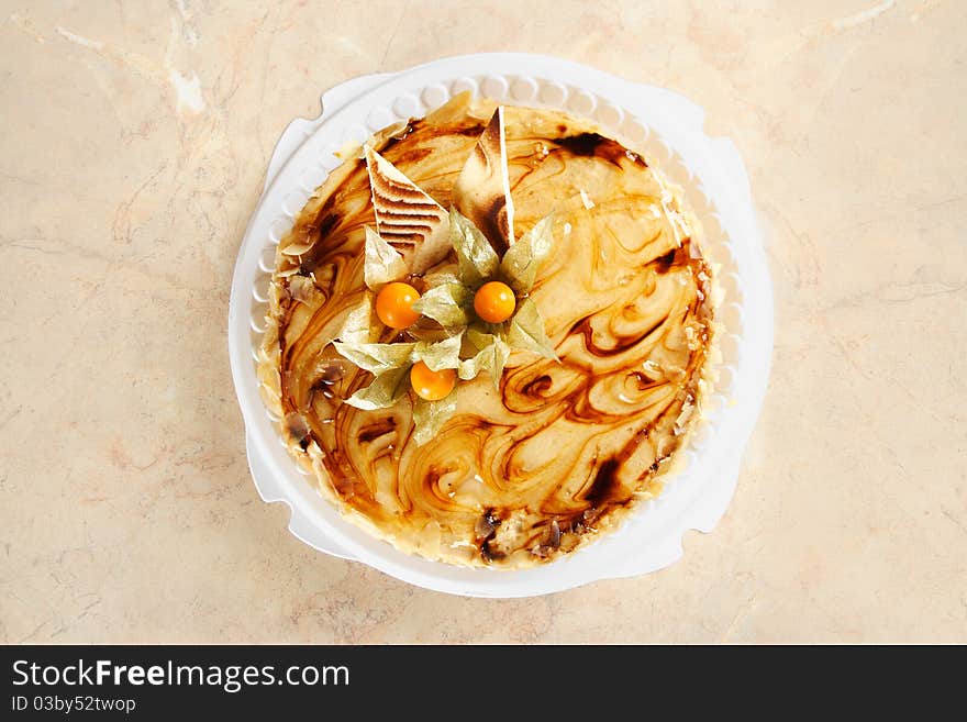 Big caramel pie with decorative berries on table, view from above