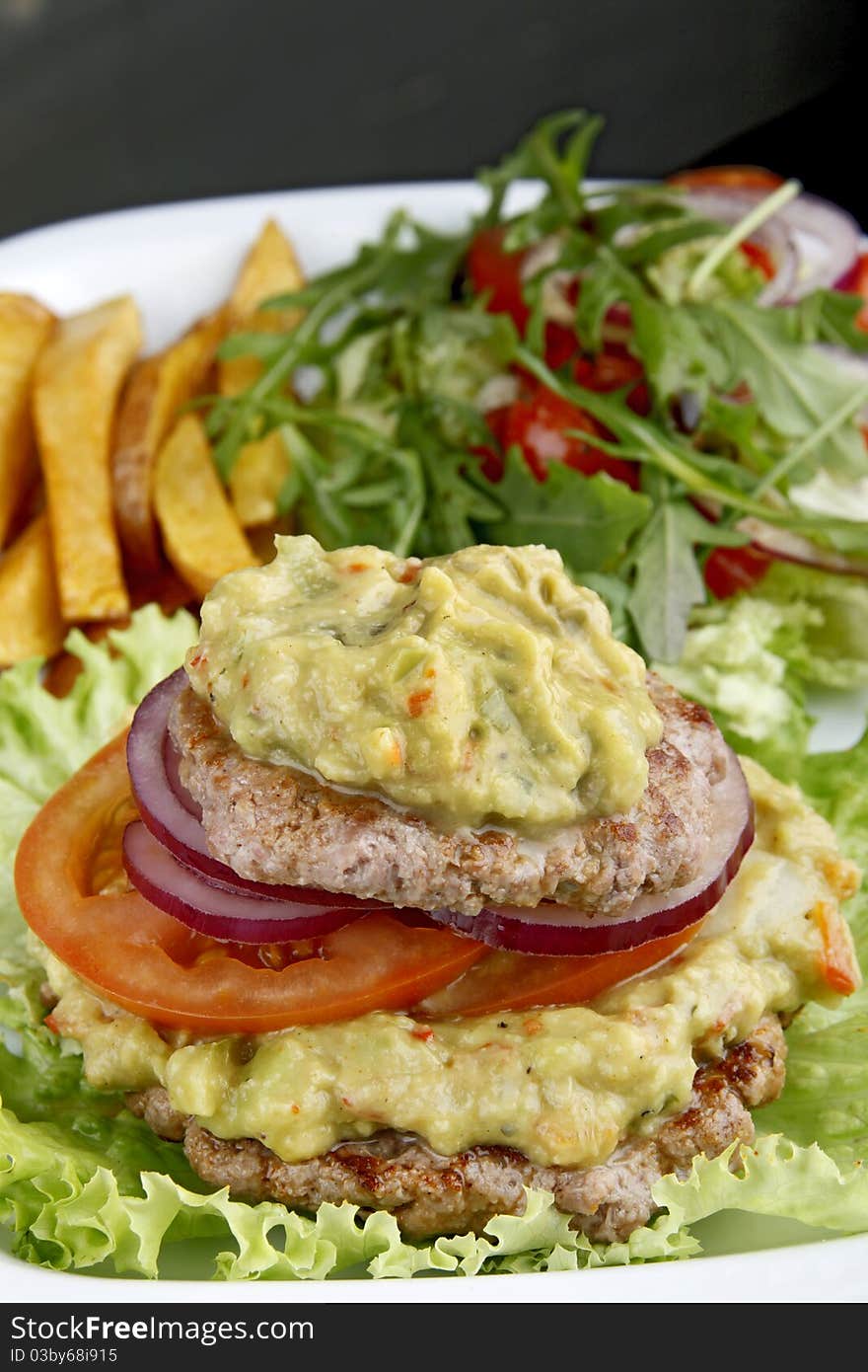 Hamburger on your plate with tomatoes and fried potatoes