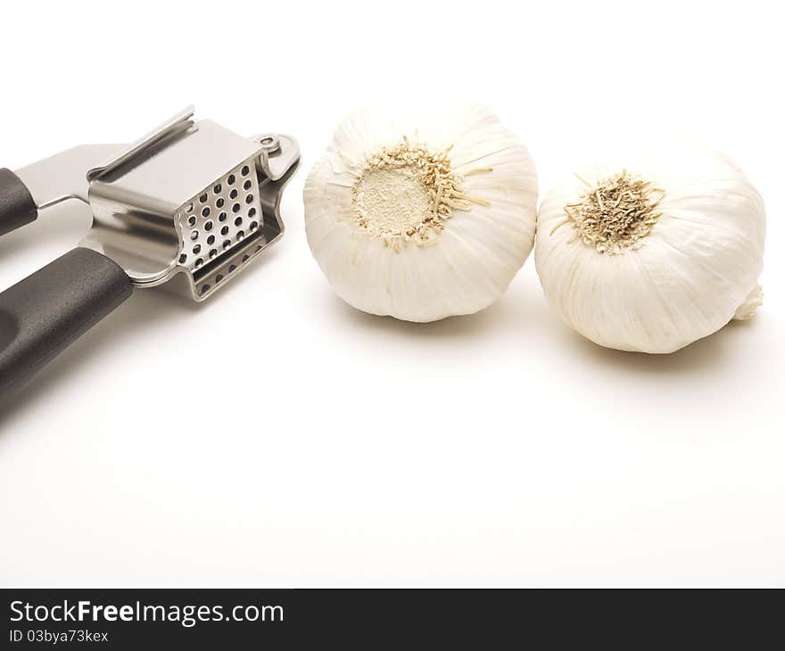 Garlic Press And Two Cloves Of Garlic