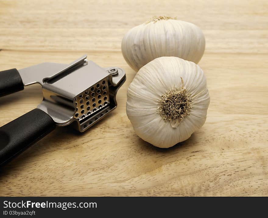 Garlic Press And Two Cloves Of Garlic