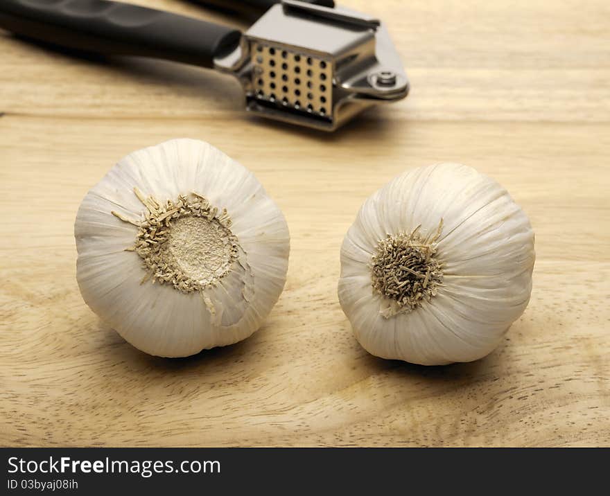 Garlic press and two cloves of garlic