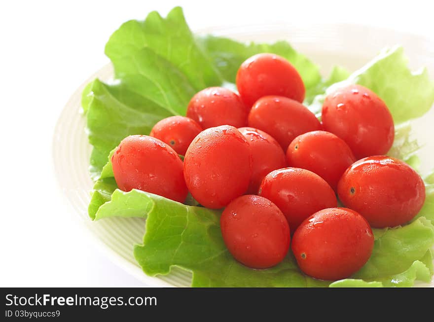 Fresh rosa tomatoes and butter lettuce on white plate. Fresh rosa tomatoes and butter lettuce on white plate