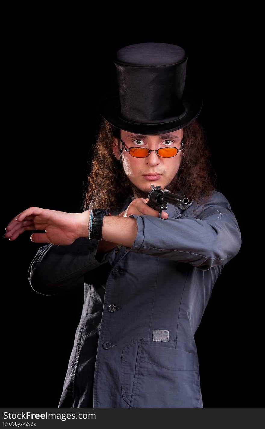 Portrait of the serious man in a top-hat with a pistol in hands