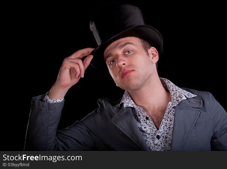 Emotional portrait of the young man in a black top-hat. Emotional portrait of the young man in a black top-hat