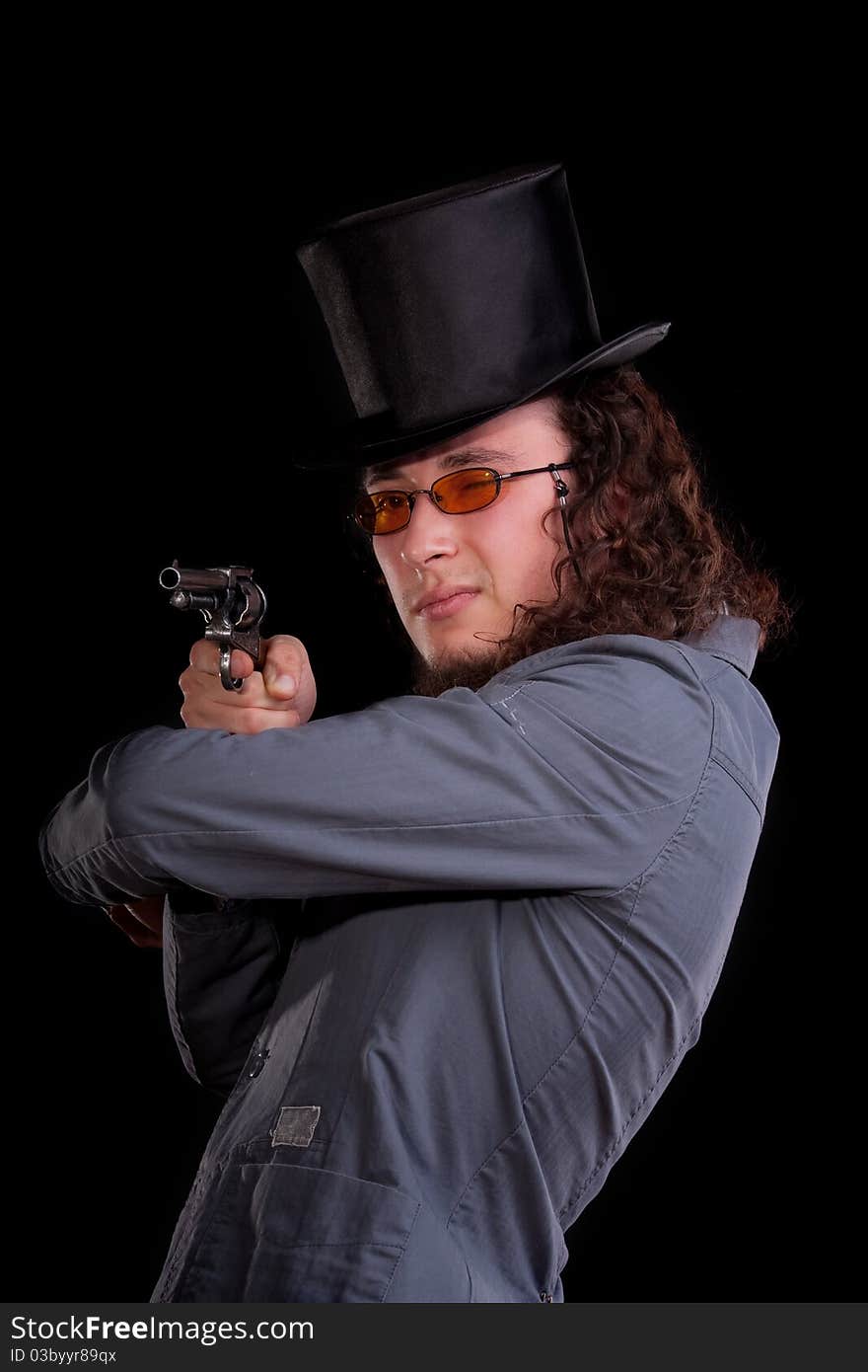 Portrait of the serious man in a top-hat with a pistol in hands