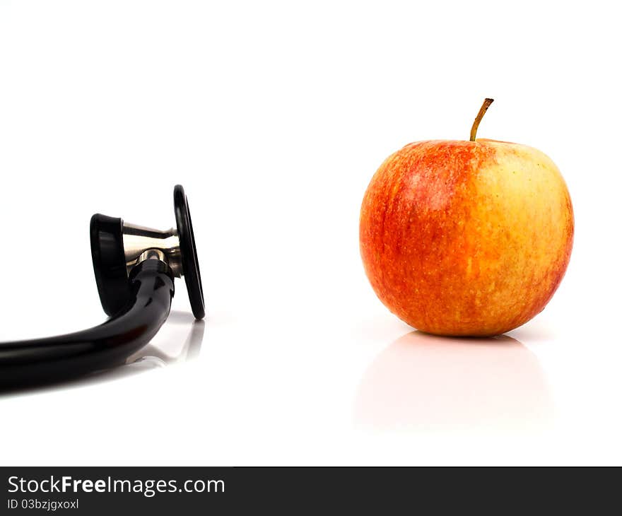 A stethoscope with a red apple with white background. A stethoscope with a red apple with white background