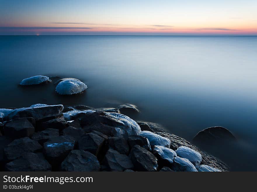 A tranquil and cold sunset at the IJsselmeer in the Netherlands. A tranquil and cold sunset at the IJsselmeer in the Netherlands