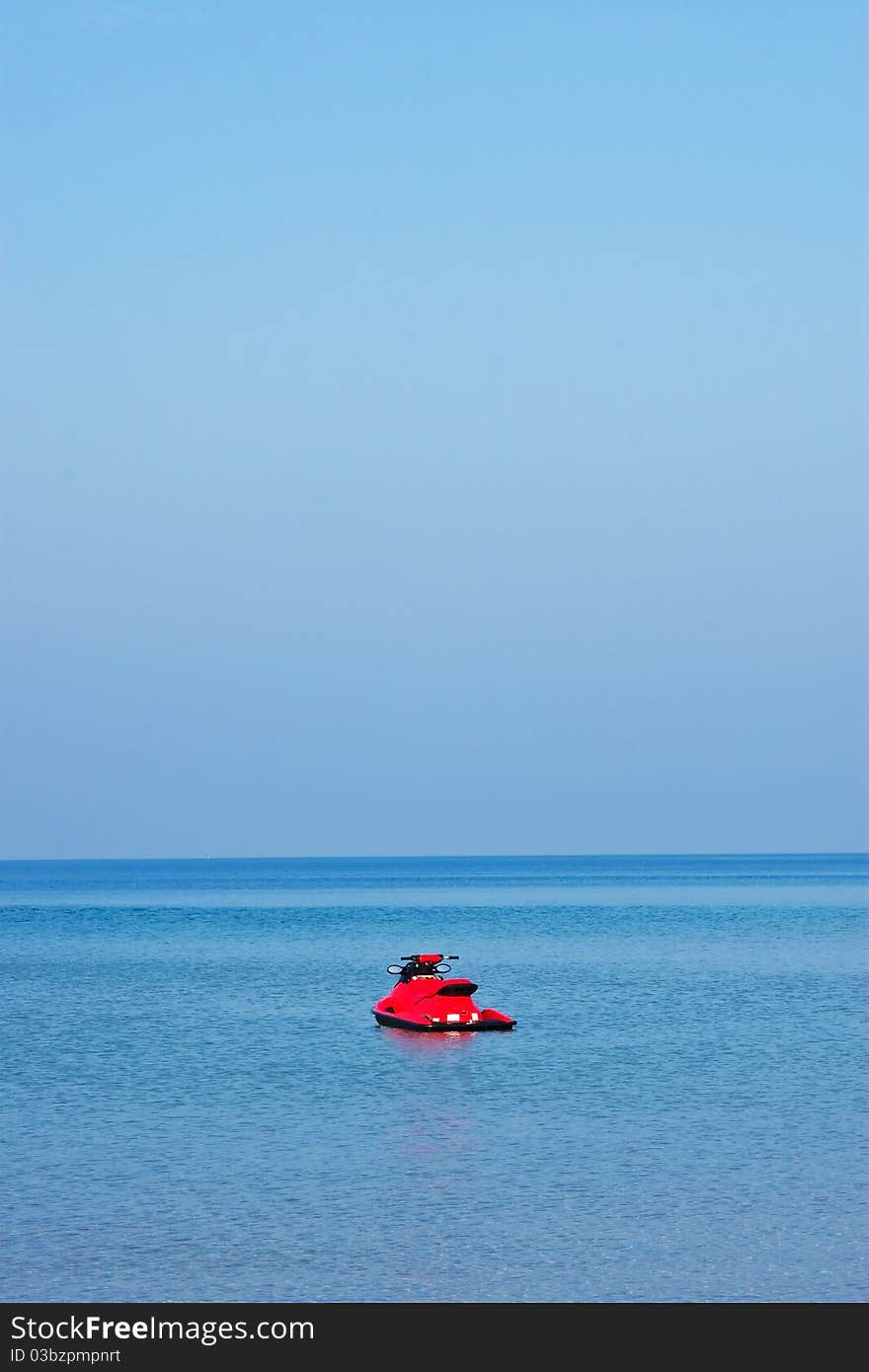 Lonely red jet ski on blue sea