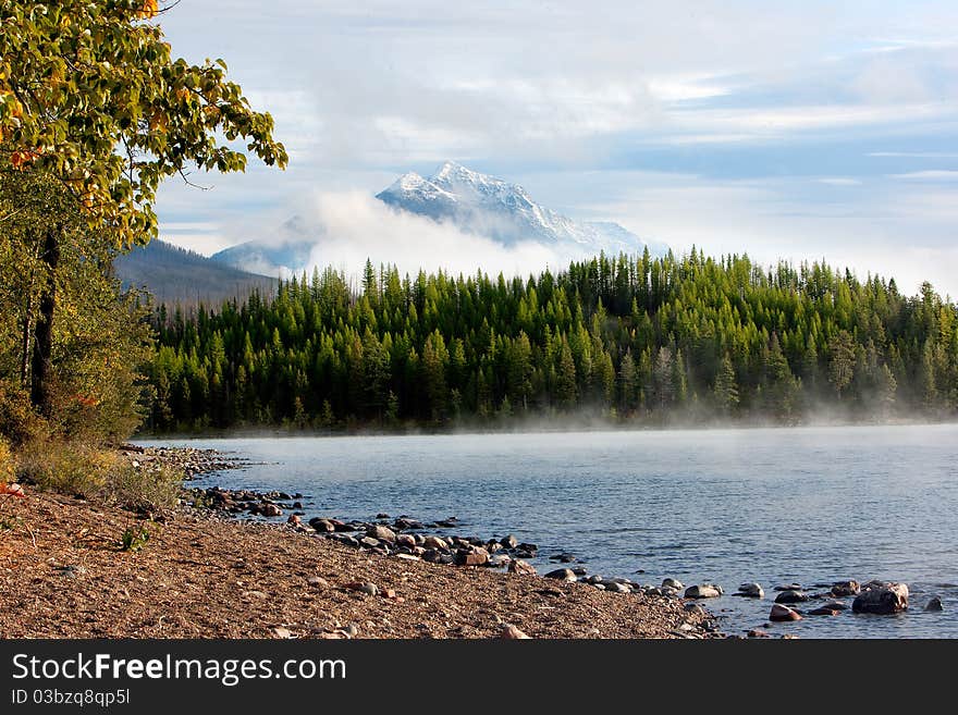 Morning steam rises off a mountain lake.