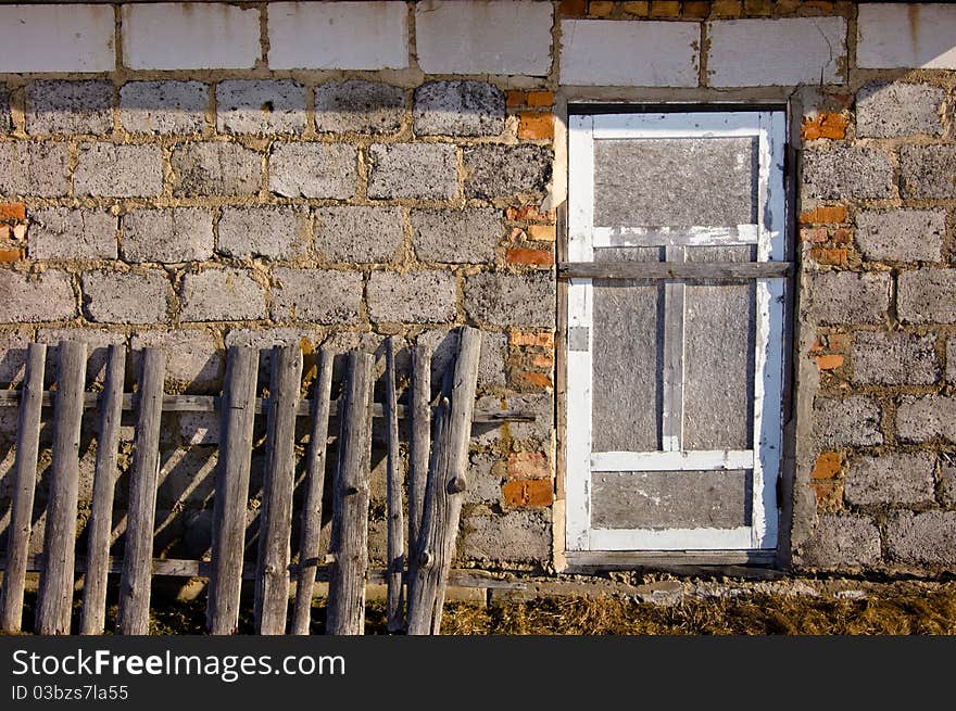 Wall of the house from blocks silicate with the closed window and a fence. Wall of the house from blocks silicate with the closed window and a fence