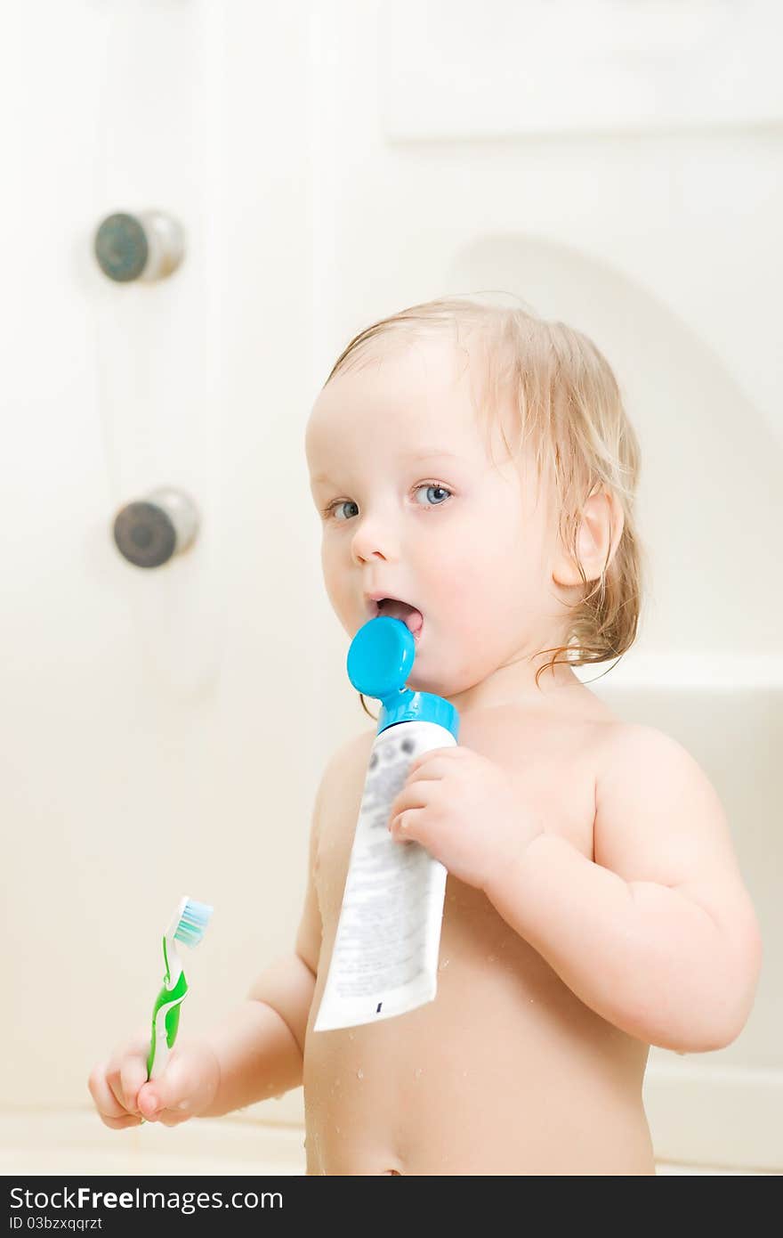 Adorable baby brushing teeth in shower holding tooth paste. Adorable baby brushing teeth in shower holding tooth paste