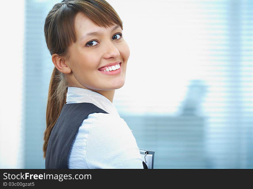 Portrait of a young businesswoman smiling against the office background