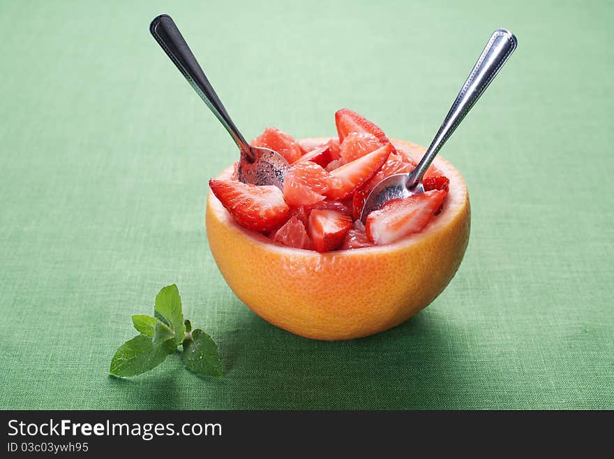 Fruit salad in hollowed-out grapefruit stuffed with strawberry. Fruit salad in hollowed-out grapefruit stuffed with strawberry