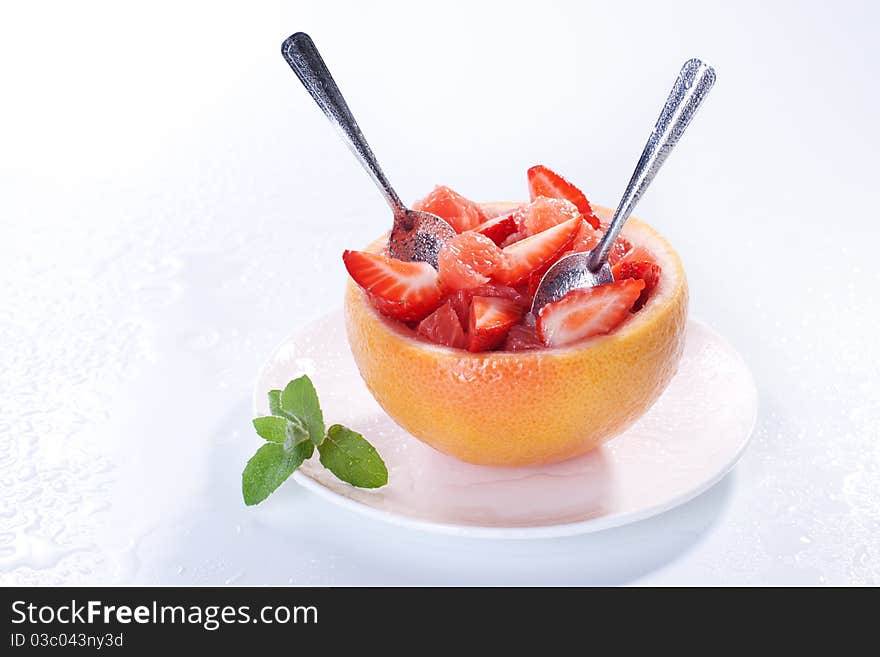 Fruit salad in hollowed-out grapefruit stuffed with strawberry. Fruit salad in hollowed-out grapefruit stuffed with strawberry