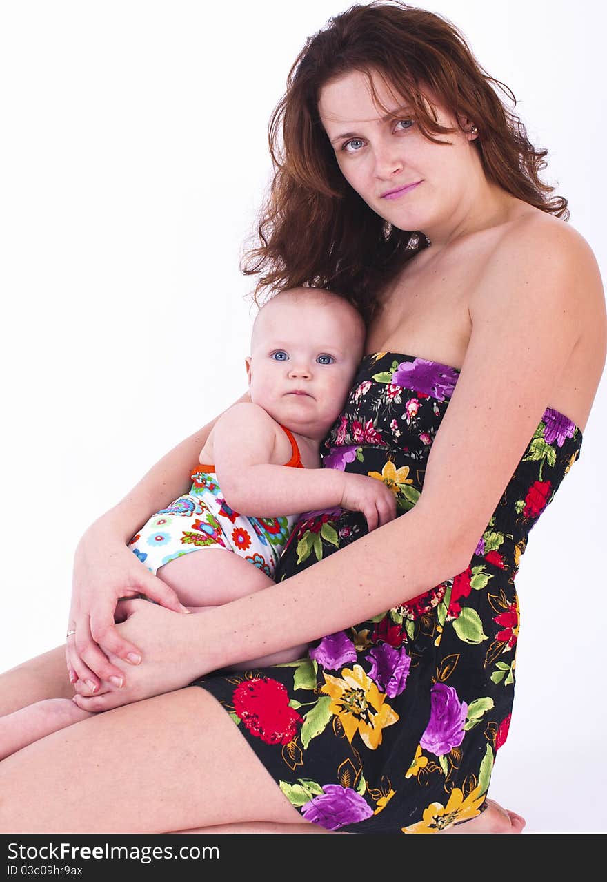 A girl sits on the lap of her mother.