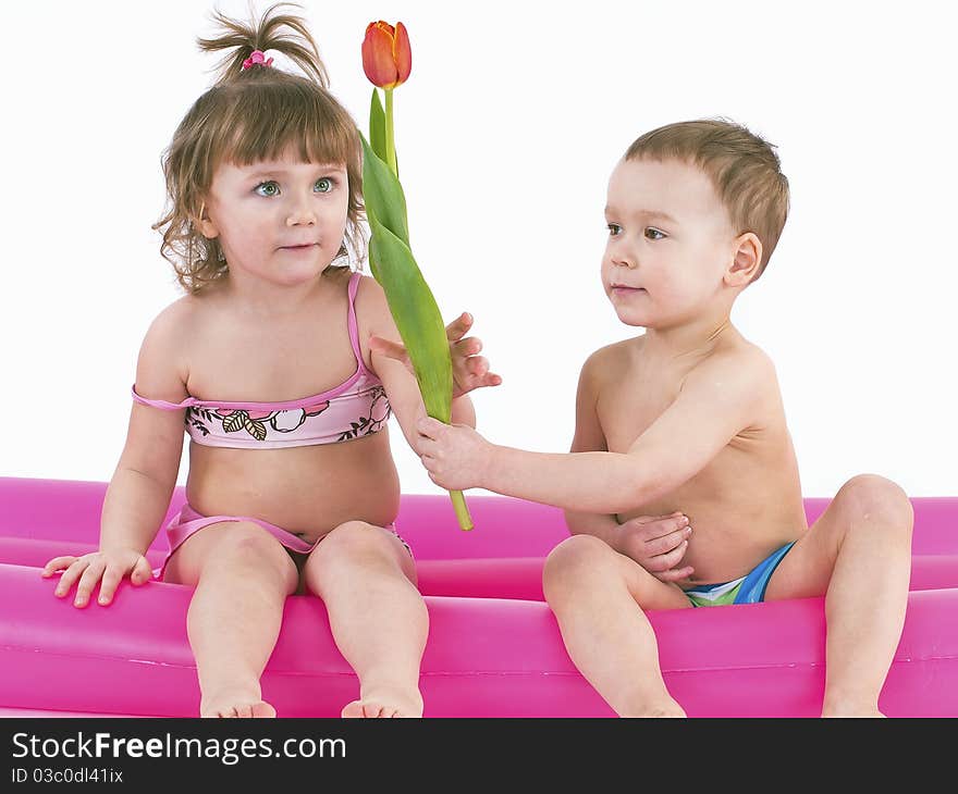 sitting on a big air mattress.Boy wants to give a girl flowers. sitting on a big air mattress.Boy wants to give a girl flowers