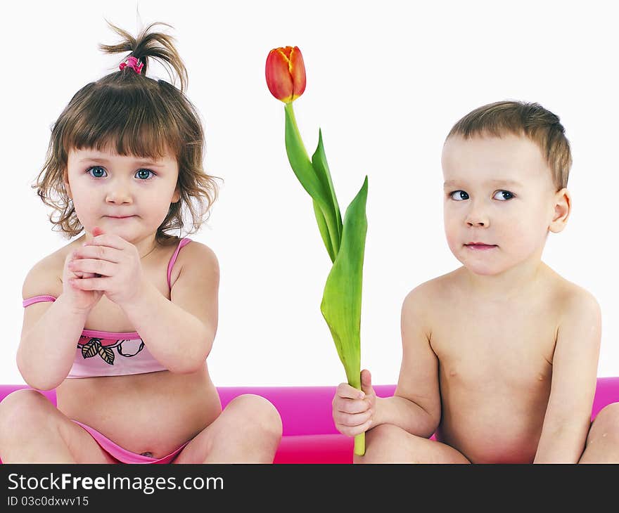 Sitting on a big air mattress.Boy wants to give a girl flowers. Sitting on a big air mattress.Boy wants to give a girl flowers