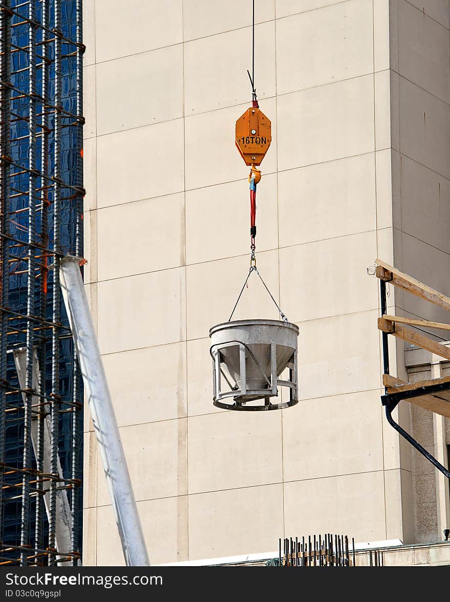 Cement bucket swinging against building. Cement bucket swinging against building