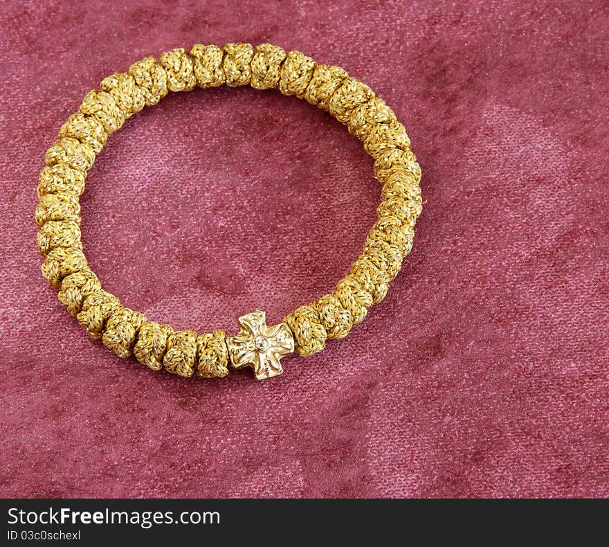 Round golden bracelet rosary over purple background