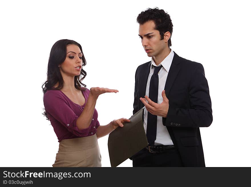 Two office workers stand and discuss matters of importance. Two office workers stand and discuss matters of importance.