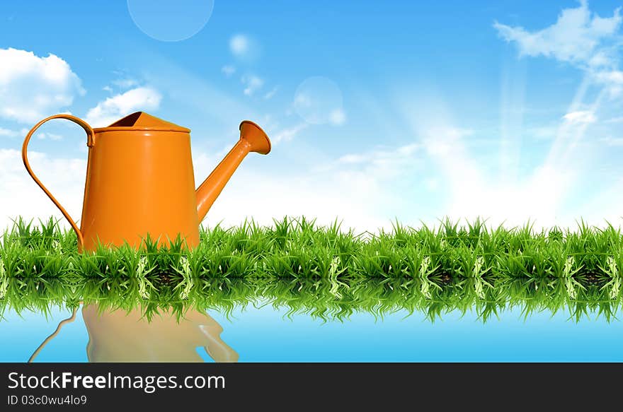 Watering Can On The Grass With The Bright Sky.