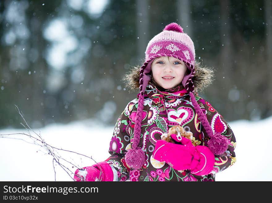 Winter portrait of beauty little girl in colorful clothes in snow