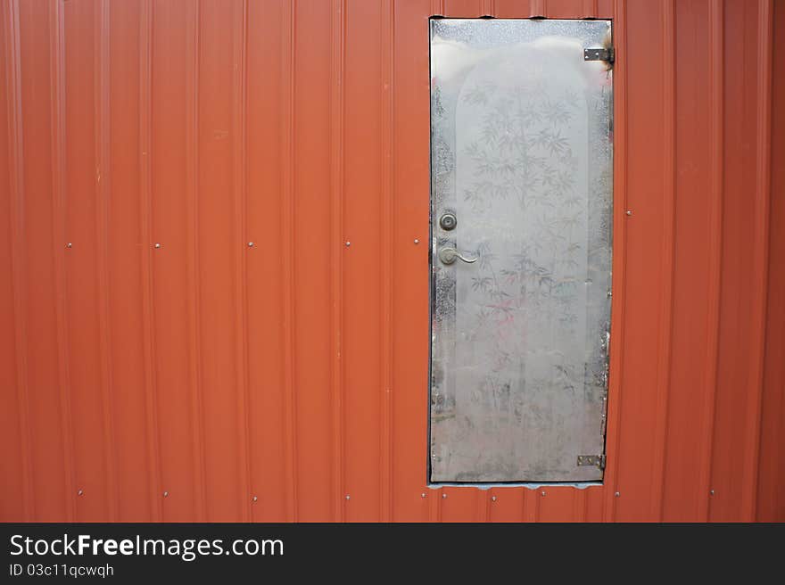 The old white steel door on the red steel wall