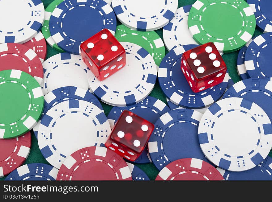 Many poker chips and dice on the green table