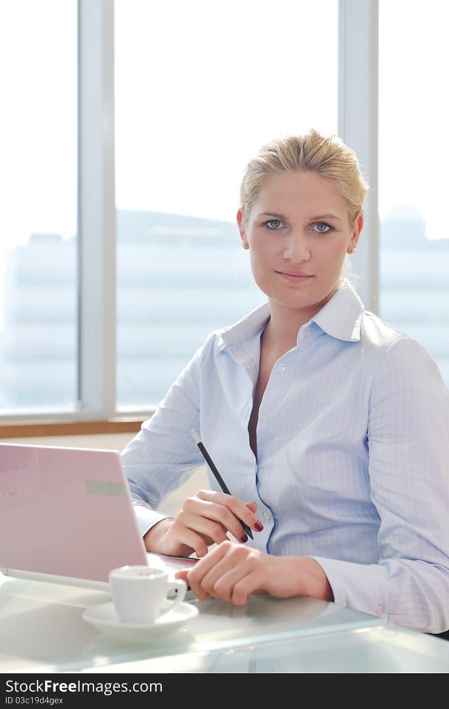 One happy young business woman working on laptop computer at group team meeting at modern office. One happy young business woman working on laptop computer at group team meeting at modern office