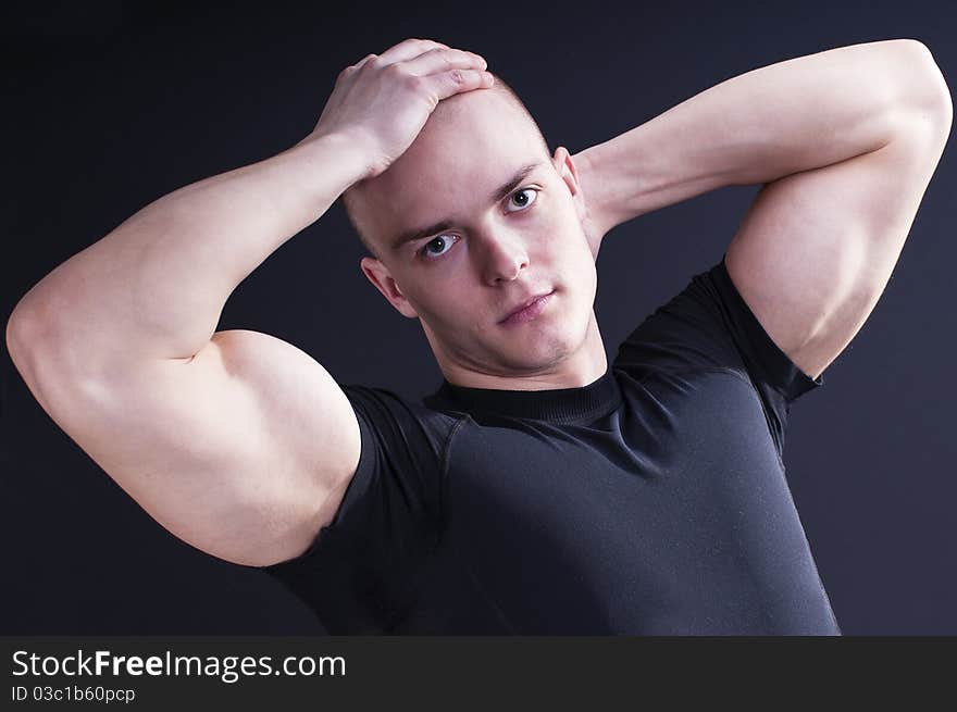 Young man showing his muscular arms. Young man showing his muscular arms