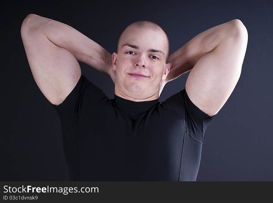 Young man showing his muscular arms. Young man showing his muscular arms