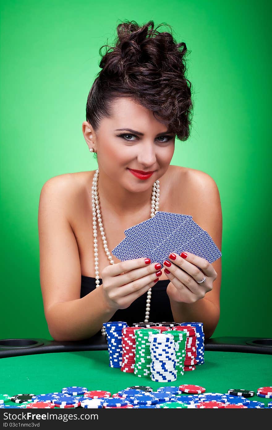 The girl in a black dress with five cards on a green background. The girl in a black dress with five cards on a green background