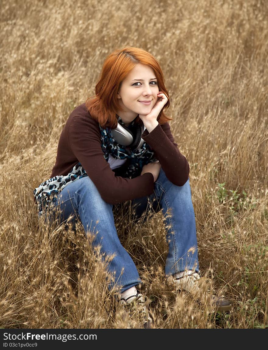 Young smiling girl with headphones at field. Young smiling girl with headphones at field.