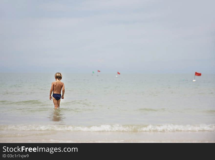 Young boy walking in the sea. Young boy walking in the sea