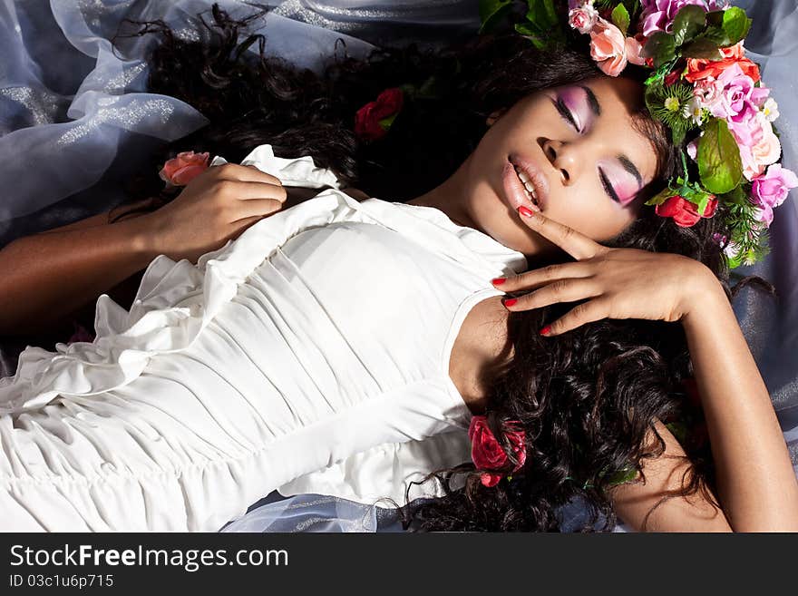 Elegant mulatto girl with circlet of flowers