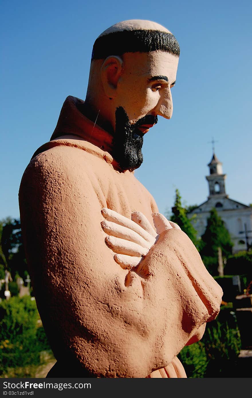 Retro monk sculpture with hands and sky background